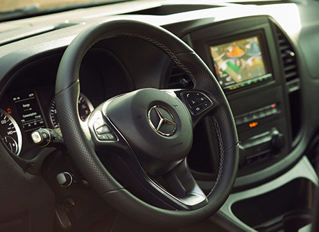 Driver’s view of the steering wheel and center console of the Metris pop top camper van.